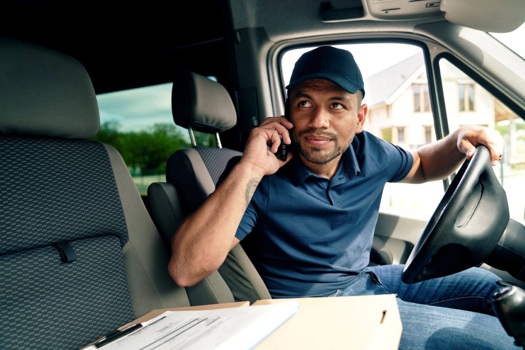 driver-with-package-looking-away-while-sitting-in-2026-01-06-08-58-26-utc